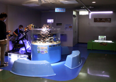 Visitors try their best to produce water current for fish at Kids Zone in Uozu Aquarium.